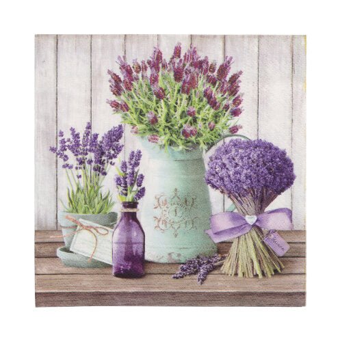 A lavender bouquet, a purple bottle, a white jug with lavender, and a green teacup are placed on wood next to PAPSTAR GmbH 20 napkins 33x33cm 3-ply 1/4-fold Design Set 3 in front of a white wooden wall.