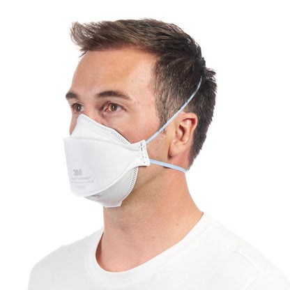 A man in a plain white shirt wears a 3M™ Aura™ Comfort Particulate Respirator 9320+ FFP2 without valve from 3M Deutschland GmbH, with two headbands and slightly facing left.