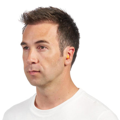 A man with short brown hair and a white shirt is seen in profile view, wearing an orange 3M™ Earplug 1100 soft foam (SNR 35 dB) from 3M Deutschland GmbH in his right ear.