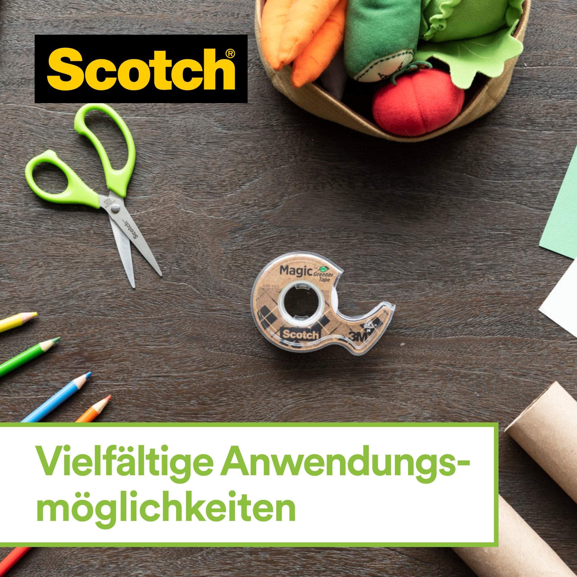 Der Scotch™ Edelstahl-Klebebandabroller und Scotch® Magic™ Klebeband von 3M Deutschland GmbH mit 66% pflanzenbasiertem Klebstoff liegen auf einem Holztisch, umgeben von grünen Scheren, Buntstiften, Papier und Stoffgemüse. Vielfältige Anwendungsmöglichkeiten.