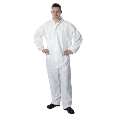 A person stands with hands on hips, wearing the Thor disposable overall Type 5+6 PE in white from Abena Re-Seller GmbH and black shoes, in front of a plain white background.