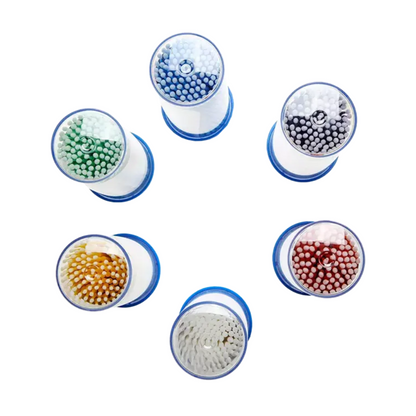 The AMPri MED-COMFORT disposable micro applicators, available in various colors, are arranged in a circular pattern and equipped with bristles in blue, white, black, green, yellow, and red. Each applicator has a blue base and is viewed from above. This arrangement is ideal for dental needs that require precise work with various color-coded tools. Presented by AMPri Handelsgesellschaft mbH.