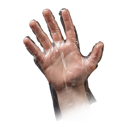 A hand is raised with the palm facing forward, wearing an AMPri MED-COMFORT PE glove hammered from AMPri Handelsgesellschaft mbH. The transparent plastic glove, often used in the food industry, shows the fingers slightly spread. The image is isolated on a white background.