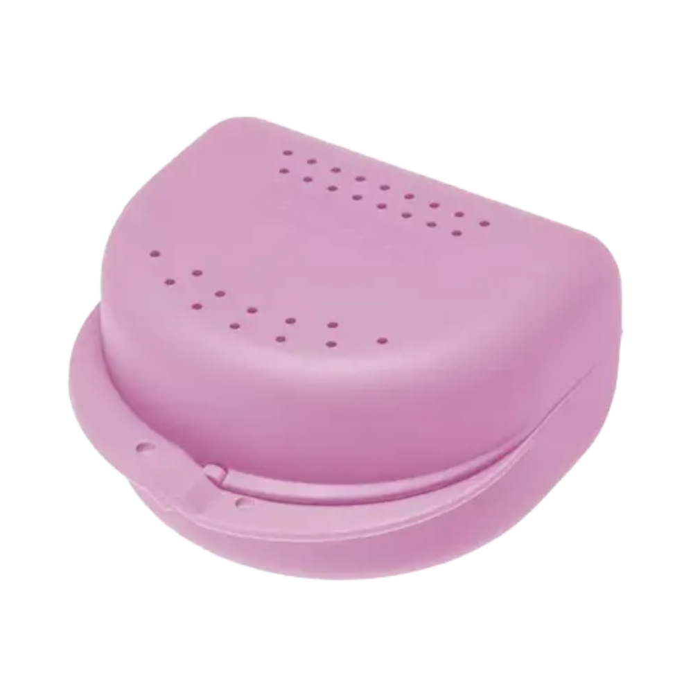 A pink, semi-circular AMPri PP Dental orthodontic box from AMPri Handelsgesellschaft mbH with a hinged lid and ventilation holes. This storage box seems ideal for storing retainers or mouthguards. It is closed and placed on a white surface, highlighting its practical applicability for orthodontic work.