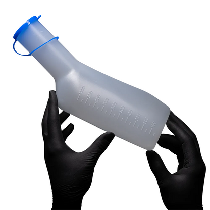 Two gloved hands hold an AMPri PP urine bottle for men from AMPri Handelsgesellschaft mbH. The bottle is translucent, has a blue cap, is autoclavable, and has measurement markings on the side. The background is plain white.