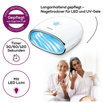 A woman is sitting on a sofa smiling and showing off her brightly painted nails. Next to her sits another woman. On the left is a product image of a Beurer MP 48 LED/UV nail dryer | Package (1 piece) from Beurer GmbH with the text: "Long-lasting care – nail dryer for LED and UV gels" and functional symbols for timer and LED light can be seen.