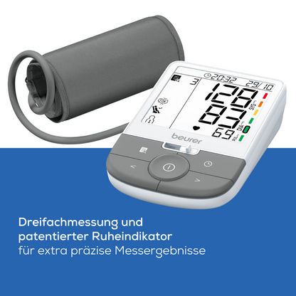 A digital blood pressure monitor with a connected cuff is displayed. Various readings are shown on the screen and the German headline reads "Triple measurement and patented rest indicator for extra precise measurement results" and highlights the Beurer upper arm blood pressure monitor BM 53 |. Package (1 piece) from Beurer GmbH with accuracy and arrhythmia detection functions.