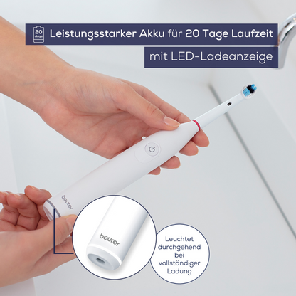 Eine Person hält eine Beurer TB 30 Elektrische Zahnbürste, verpackt als 1 Stück. Der Text auf dem Bild hebt hervor, dass diese Zahnbürste der Beurer GmbH einen leistungsstarken Akku mit einer Laufzeit von 20 Tagen hat, über eine LED-Ladeanzeige verfügt und oszillierende Technologie verwendet. Eine Nahaufnahme zeigt, dass die Ladeanzeige bei voller Ladung kontinuierlich leuchtet.