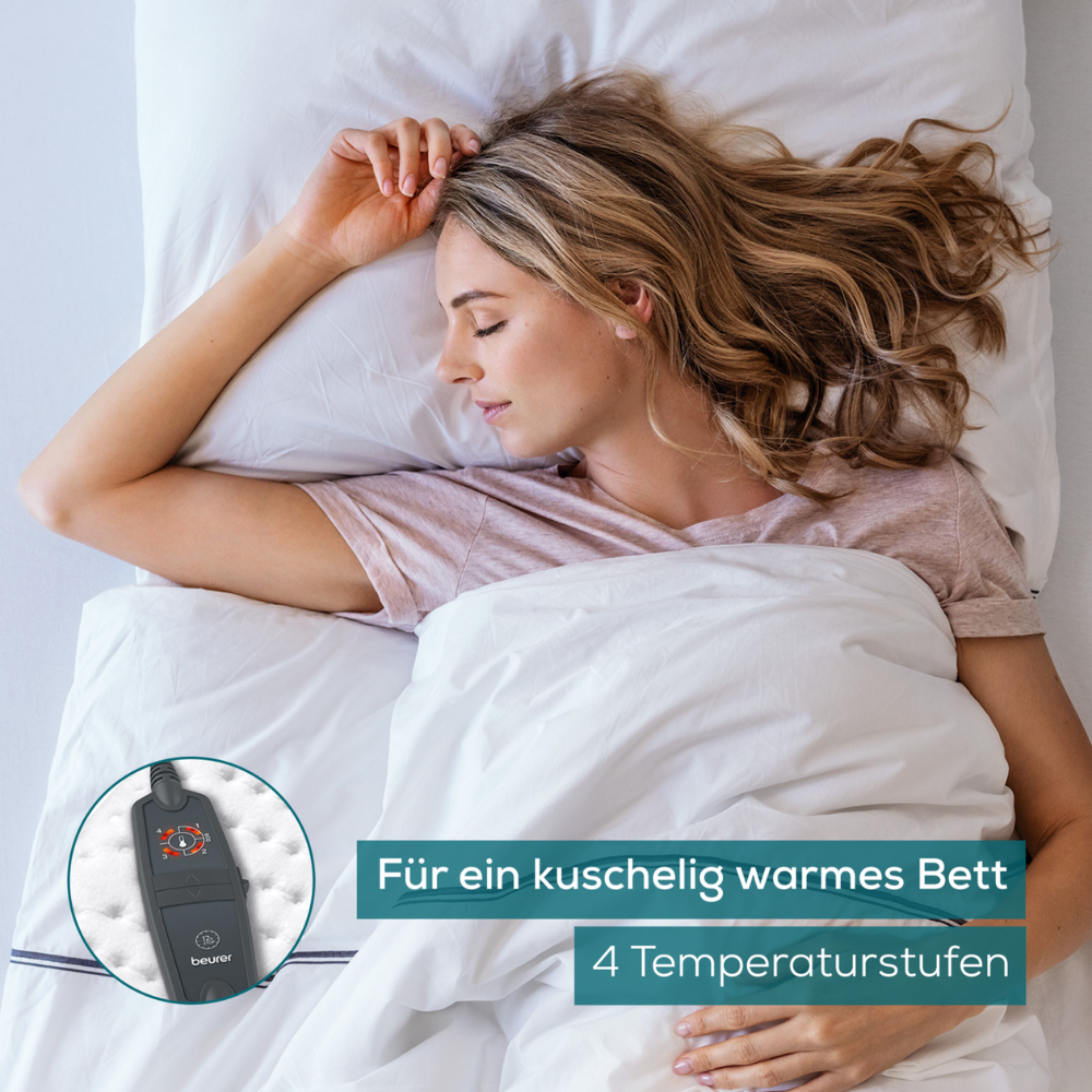 A woman with blonde hair sleeps in a bed with white bedding. In an inset, a dark-colored electronic device with buttons is visible, probably a Beurer warming underblanket UB 60 Green Planet control for a heated blanket from Beurer GmbH. The German text reads: "For a cozy warm bed" and "4 temperature levels."