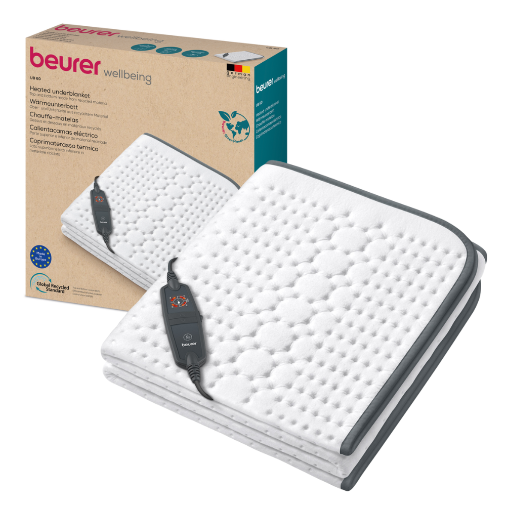 Image of a Beurer warming underblanket UB 60 Green Planet. The blanket is white with a quilted pattern and dark edging. A control device with a screen and buttons offering 4 temperature levels is attached to the blanket. In the background, the product packaging of Beurer GmbH is visible, presenting the blanket and information.