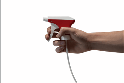 A hand holds the nozzle separated from a bottle of the Altruan Sprayer K2 (white/red, 25 mm, nozzle MS 0.6, without suction filter, riser tube 21.5 cm), whose tube is visible against a plain white background.