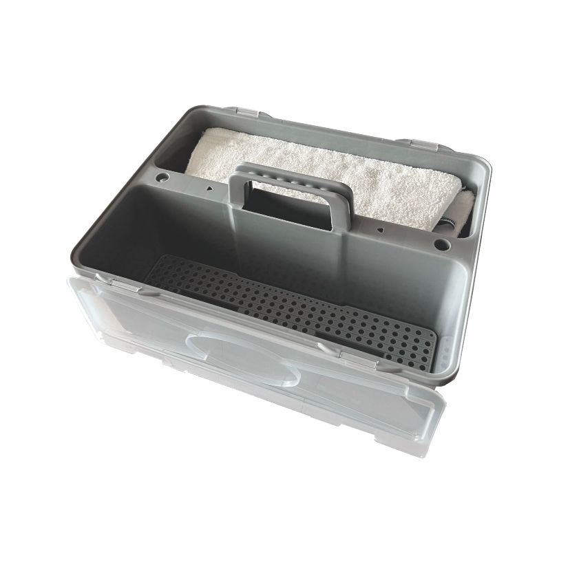 A gray Arcora X-Line Duo plastic box from Arcora International GmbH with lid, plastic handle, and supplied bottom sieve; one compartment is covered with a white towel, the others are empty. Ideal for storing household accessories.