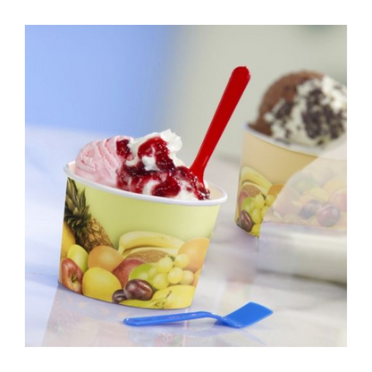 A Starpak ice cream cup decorated with fruit motifs with two scoops of whipped cream and berry sauce, along with a red spoon. Next to it lies a blue plastic spoon on the table.