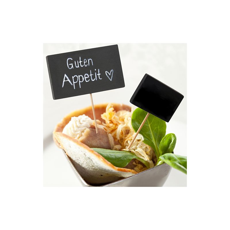 A dish in a bowl with leafy greens and roasted onions is crowned with two PAPSTAR 100 Fingerfood - Picker signs by PAPSTAR GmbH on bamboo skewers; one reads "Guten Appetit" with a heart, the other is blank.