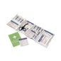 Inside is an open first aid kit containing various bandaging materials, a medical scissors, a green instruction manual, and a small white guide from the Holthaus Medical GmbH & Co. KG's full assortment first aid kit DIN 13157 according to the DIN 13157 standard.