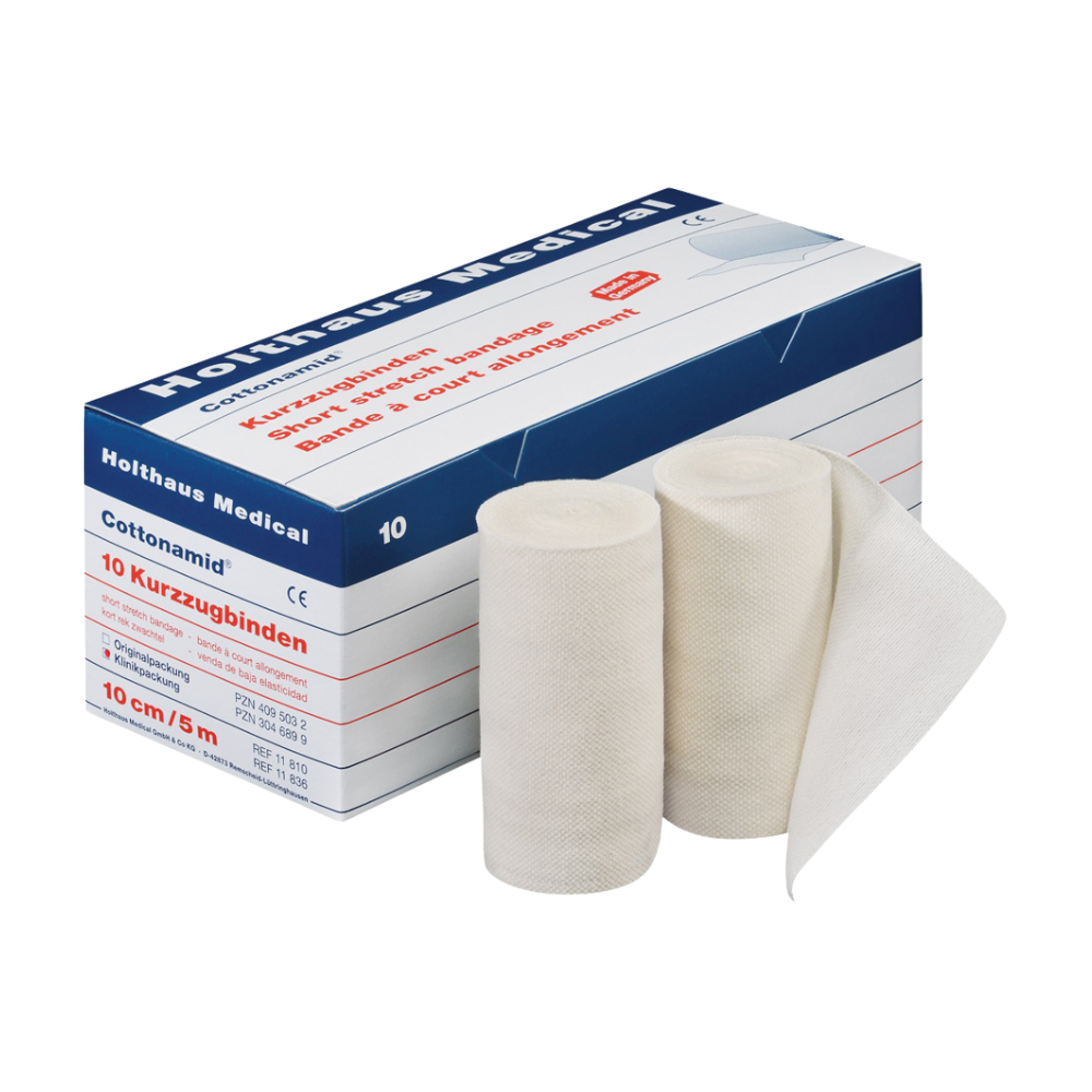 Pictured is a box of Holthaus Cottonamid® short-stretch bandage, with two unrolled white elastic bandages in front. The box is designed in white and blue with red text and contains 10 rolls, each 10 cm wide and 5 meters long, ideal for compression therapy. This product is from Holthaus Medical GmbH & Co. KG.