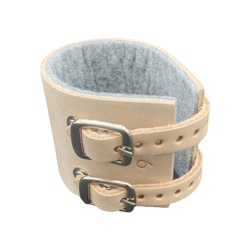 The Holthaus Ypsimed wrist strap from Holthaus Medical GmbH & Co. KG features two adjustable straps with metal buckles and is lined inside with soft, gray fabric for added comfort. The light beige wrist cuff also has several holes for size adjustment, making it the perfect example of a leather wrist strap.