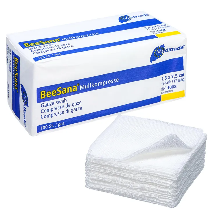 The image shows a box labeled “Meditrade BeeSana® gauze compress, non-sterile” next to a stack of white gauze compresses, ideal for effective wound care. The box measures 7.5 x 7.5 cm and contains 100 pieces. These gauze compresses are neatly stacked in front of the box, manufactured by Meditrade GmbH.