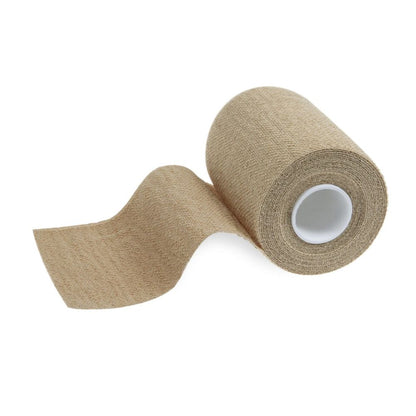 A roll of beige self-adhesive tape, like the Meditrade ABE® extra adhesive cohesive short-stretch bandage from Meditrade GmbH, is partially unrolled to reveal its texture. With a visible white cylindrical core, this versatile tape is perfect for medical or sports applications.