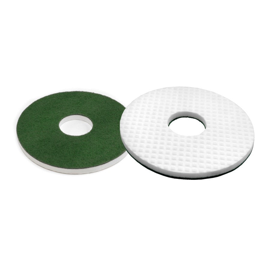 Pictured are two round floor pads: an Arcora Melamine Round Pad, compressed with a green pad backing and a textured, grid-like pattern, and both have a round center hole. Brand: Arcora International GmbH.