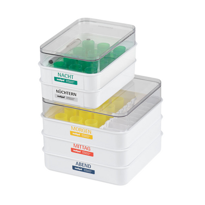 The SATZ melipul meal tray 12 VF-26 with reusable cup from Helmut Schwarz GmbH consists of compartments labeled "Night," "Fasting," "Morning," "Noon," and "Evening." Each compartment contains color-coded tubes arranged by time of day to allow precise medication delivery.