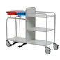 The Novocal station trolley is made of stainless steel with fully welded pipe connections and features three shelves, four wheels, two top-mounted containers (red and blue), and a practical foot pedal at the bottom.