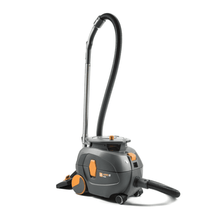 Ein TASKI AERO 8 PLUS Staubsauger, bereitgestellt von Diversey Deutschland GmbH & Co. OHG, in Grau und Orange, steht aufrecht. Dieser kompakte und leistungsstarke Kesselsauger verfügt über einen langen flexiblen Schlauch und hat einen zylindrischen Körper mit großen Hinterrädern und kleineren Vorderrädern für hervorragende Mobilität und effizientes Reinigen. Sein Betrieb wird durch Flüstertechnologie für einen leisen Betrieb verbessert.