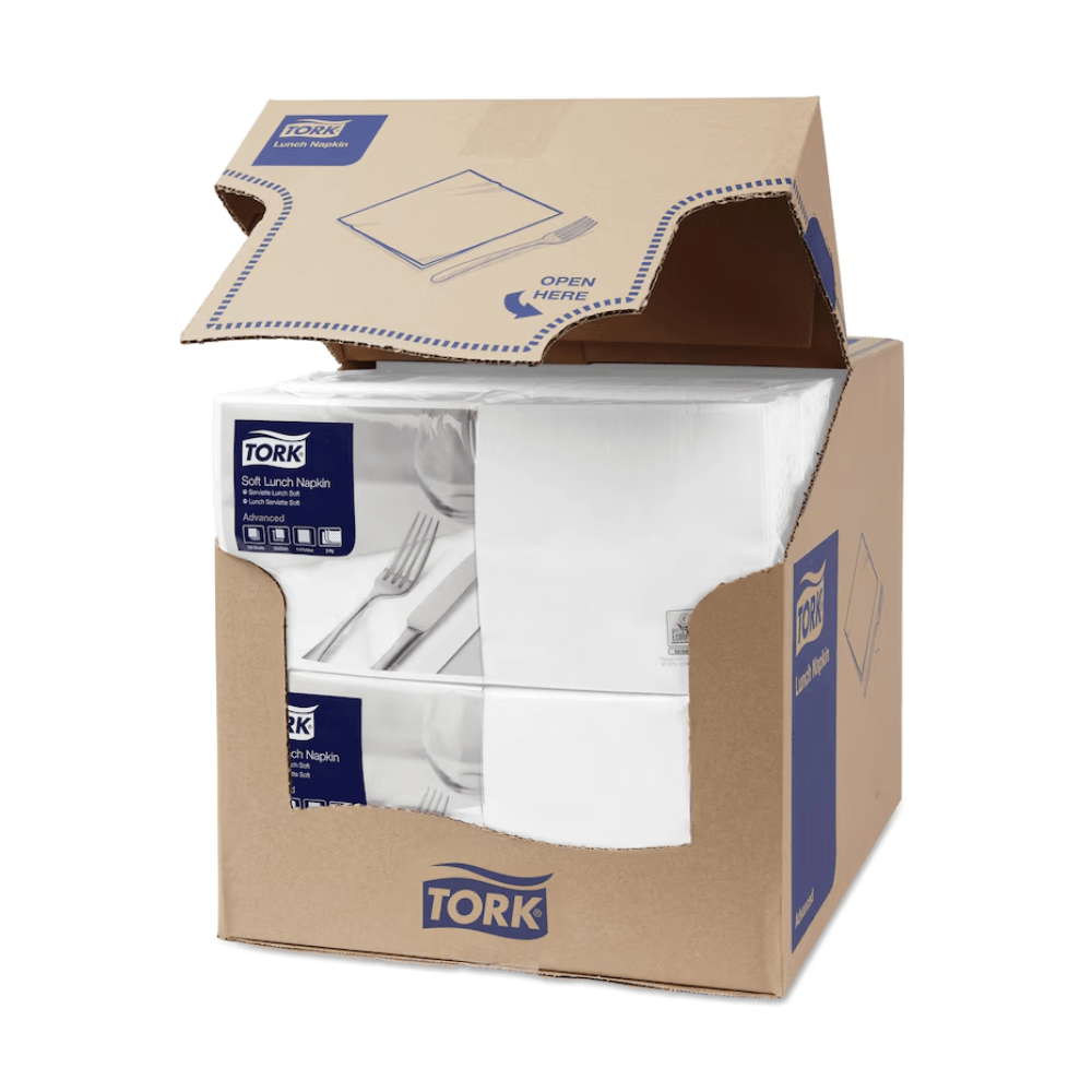 A box of Tork 477414 Soft Lunch Napkins White Advanced 3-ply is partially open, revealing four stacks of three-ply, industrially compostable white napkins. The box features the blue-and-white branding of TORK – Essity Professional Hygiene Germany GmbH – along with product information and a clear “Open here” instruction on the top flap.