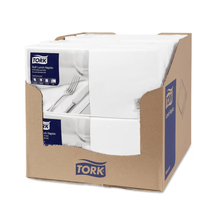 One carton contains several packs of Tork 477414 Soft Lunch Napkins, each of which bears the TORK logo and product information. The napkins, which are 3-ply for longer shelf life, are neatly stacked in the partially opened box.