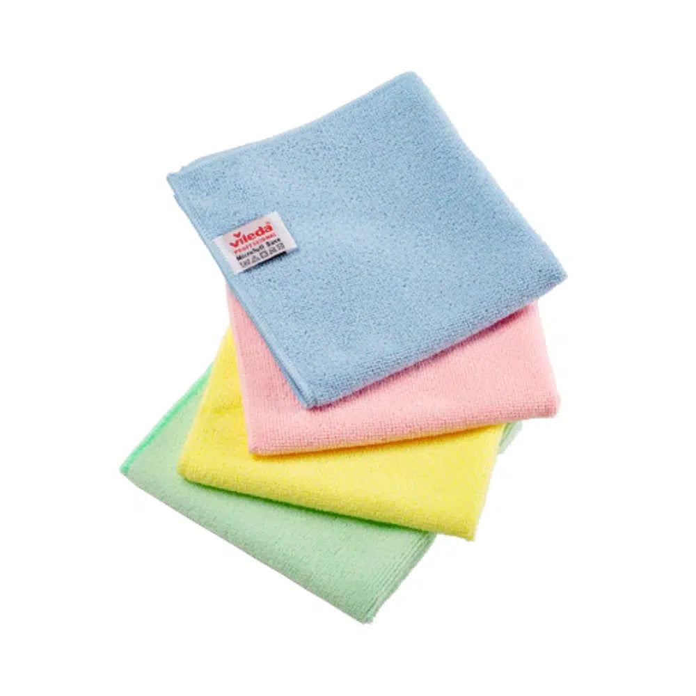 Three Vileda Professional MicroTuff Base microfiber cloths in pastel tones – blue, pink, and yellow – are neatly stacked on a green background. A small label with text is attached to the blue cloth. This simple scene against a plain white background meets the standards of the Nordic Swan Ecolabel.