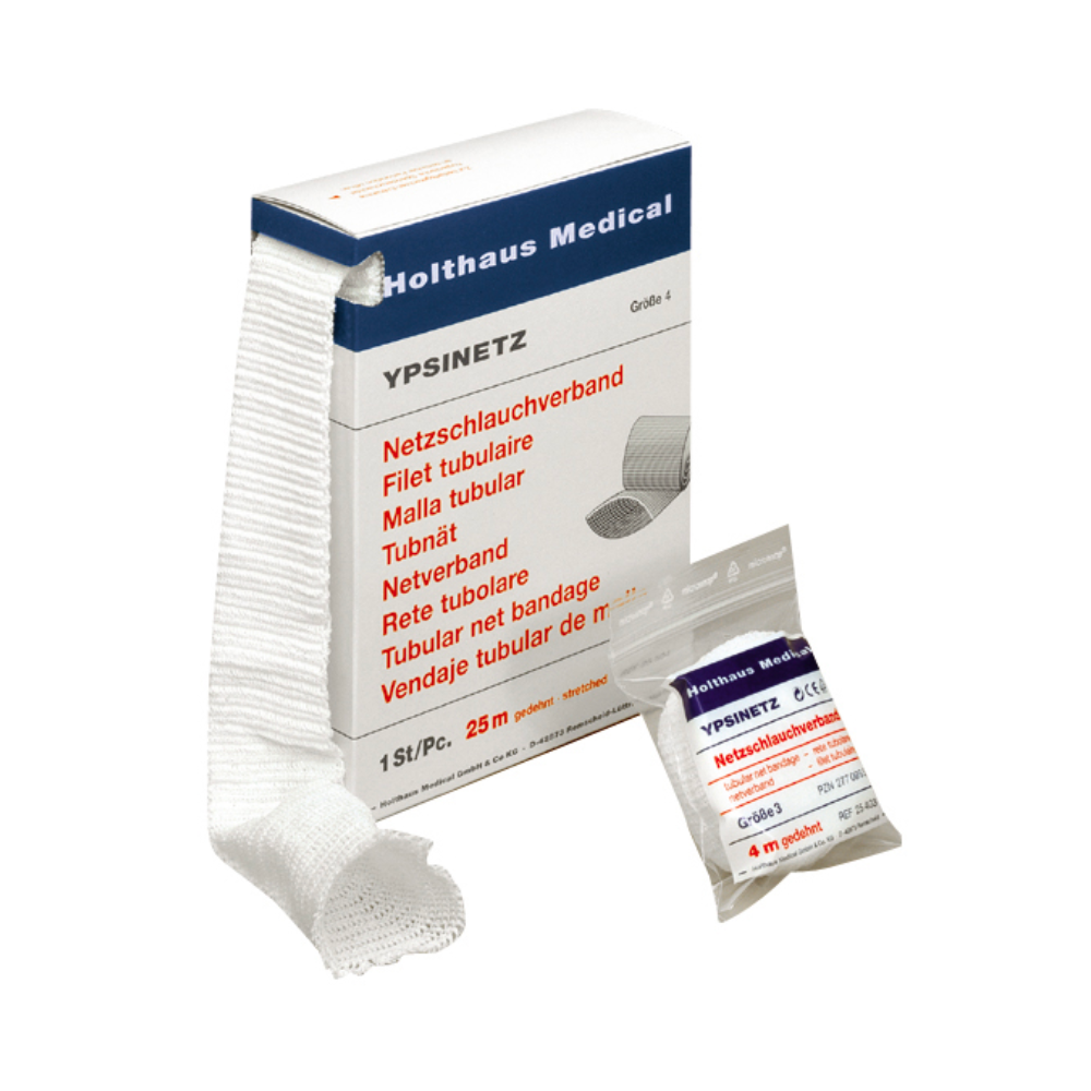 Behind the partially unrolled bandage, there is a box with a package of Holthaus Ypsinetz net tubular bandage Grade 4 from Holthaus Medical GmbH & Co. KG. Texts in different languages are printed on the box, and the package is positioned in front of it.