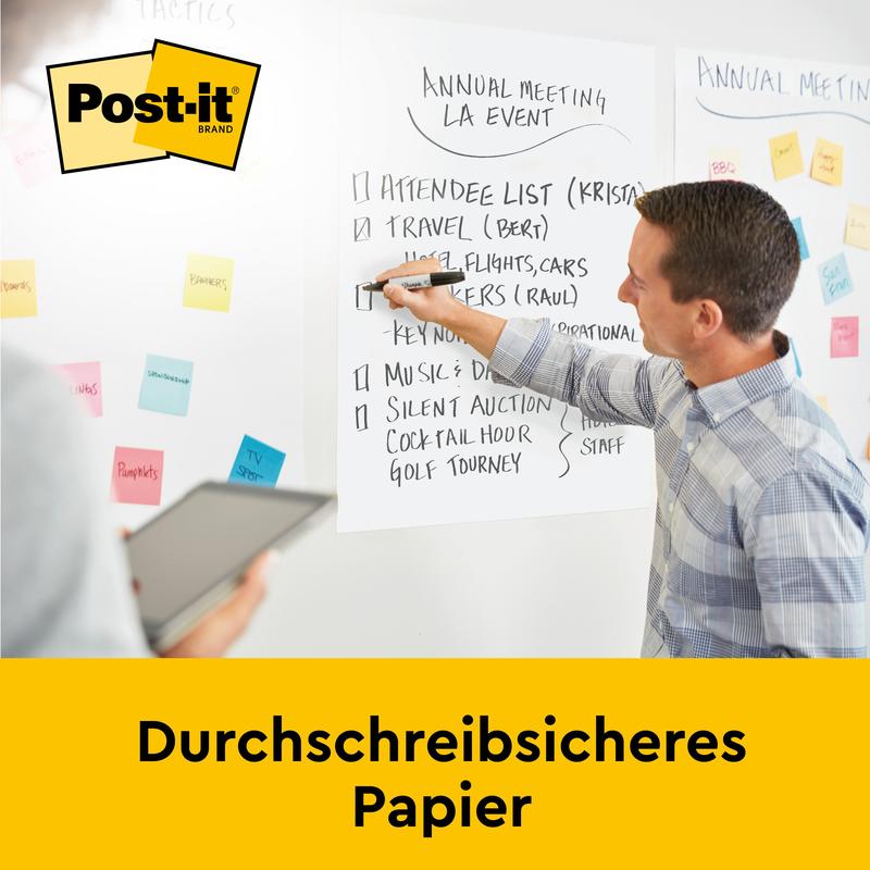 During a meeting, a person writes on a whiteboard while another uses a tablet. On the wall hangs a Post-it® Super Sticky self-adhesive Meeting Chart/Flipchart by 3M Deutschland GmbH with colorful sticky notes and bleed-through resistant paper.