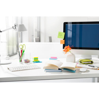 A tidy desk with a computer monitor displaying sticky notes, an open book, pens in a glass, a case, an orange flower in a vase, and colorful 3M Deutschland GmbH Post-it® Index Tabs Mini (11.9 mm x 43.2 mm) can be seen.