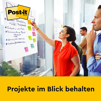 A woman writes on a Post-it® Super Sticky self-adhesive Meeting Chart (58.4 x 50.8 cm, 20 sheets) by 3M Deutschland GmbH, which is mounted on an office wall. Two people stand beside it. Below it says: "Keep projects in view."