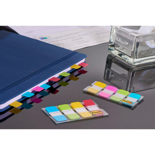Post-it® Index Strong Ablagetabs von 3M Deutschland GmbH in Blau, Violett, Rosa und Gelb (15,8 mm x 38,1 mm) sind am blauen Ordner angebracht; zwei Packungen für effiziente Dokumentenorganisation liegen auf dem Tisch.
