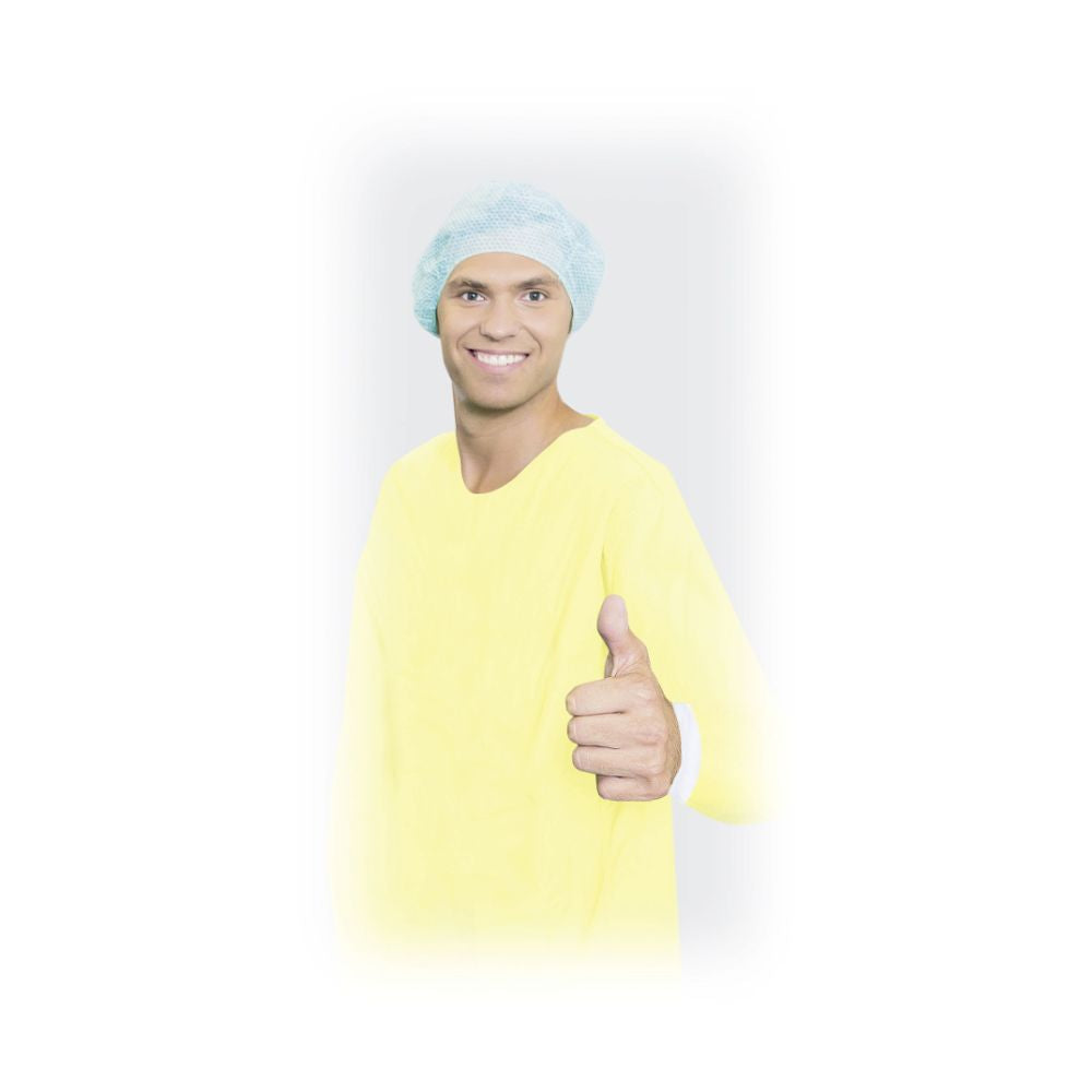 A person in a yellow Meditrade BeeSana® PP/PE gown XL (26 g, by Meditrade GmbH) and a blue hairnet smiles and gives a thumbs up. The background is solid white with a softly faded edge around the figure.
